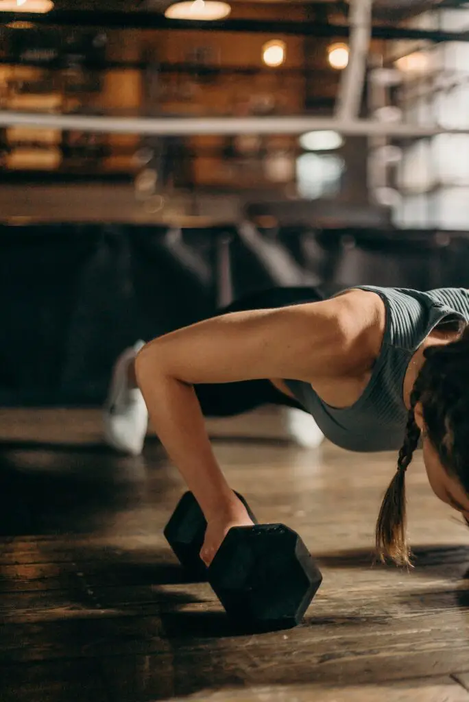 woman doing push ups with dumbbells