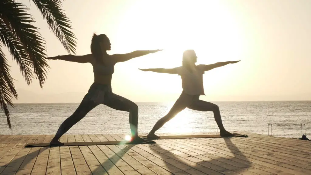 Two women doing Warrior II yoga pose