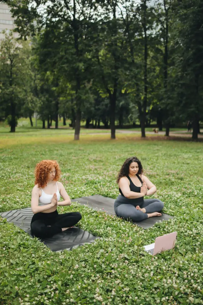 Two women doing double pigeon pose