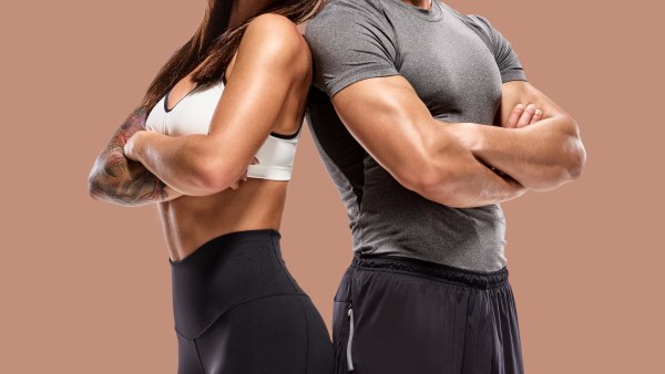 Man and woman side by side flexing chest muscles